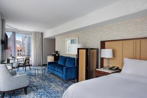 a hotel room with a bed and a blue couch at InterContinental New York Times Square, an IHG Hotel in New York