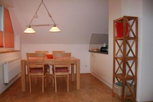 a kitchen with a dining room table and chairs at Nickelshus-Whg-Veit in Sankt Peter-Ording