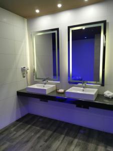 a bathroom with two sinks and two mirrors at Hotel Plaza Arteaga in Monterrey