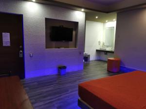 um quarto com uma cama e uma televisão na parede em Hotel Plaza Arteaga em Monterrey