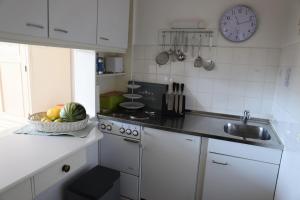 uma cozinha com um lavatório e uma taça de fruta no balcão em Ferienwohnung-Kolberger em Westerland