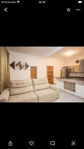 sala de estar con sofá blanco y cocina en Villa Nobre Trancoso, en Trancoso