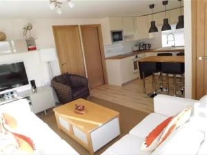 een woonkamer met een witte bank en een keuken bij Surfside Chalet in Dunbar