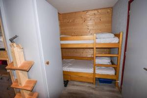 a small room with two bunk beds and a ladder at Le Relai S31 - Grand et lumineux studio avec coin montagne 4-6 pers, tout équipé, avec WIFI, à 30m des pistes avec un grand balcon, DRAPS NON COMPRIS in Saint-Jean-d'Aulps