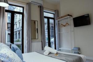 Un dormitorio con una cama y una ventana grande. en Casa Lemus, en Madrid