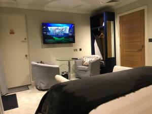 una camera con letto e TV a parete di Hillside Farm Barn a Woking