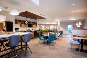 a kitchen and dining room with tables and chairs at EVEN Hotels Denver Tech Center-Englewood by IHG in Centennial