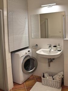 a bathroom with a washing machine and a sink at St. Prokop Luxury Apartments 256 in Boží Dar