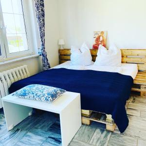 Kleines Ferienzimmer Uckermark في Casekow: غرفة نوم مع سرير وبطانية زرقاء