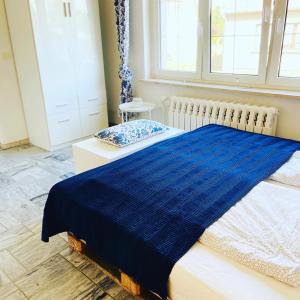 a bedroom with a bed with a blue blanket at Kleines Ferienzimmer Uckermark in Casekow +19 photos