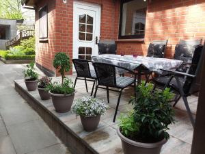 a patio with a table and chairs and potted plants at Amera-Ferienwohnung in Lübeck