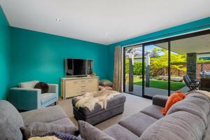 - un salon avec un canapé et une télévision dans l'établissement Roys Bay Lodge - Wanaka Holiday Home, à Wanaka