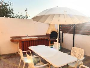 a table and chairs with an umbrella on a patio at Casa completa en La Laguna Vivienda Vacacional in Las Lagunas