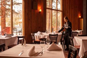 uma mulher numa sala de jantar com mesas em Mount Princeton Hot Springs Resort em Buena Vista