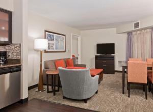 a living room with a couch and a dining room at Staybridge Suites - Charlotte Ballantyne, an IHG Hotel in Charlotte