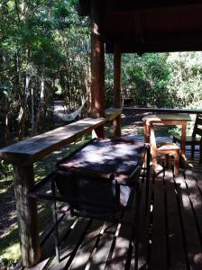 einen Picknicktisch und eine Bank auf einer Veranda in der Unterkunft Cabaña en Río Puelo in Puelo