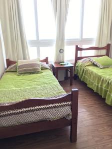 2 camas individuales en una habitación con ventana en Laguna del Mar - La Serena, en La Serena