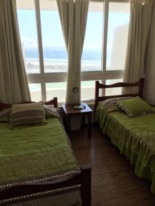 2 camas en una habitación con ventana grande en Laguna del Mar - La Serena, en La Serena