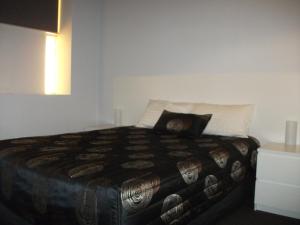 a bedroom with a bed with a pillow on it at Daydream Motel and Apartments in Broken Hill