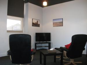 a waiting room with two chairs and a television at Daydream Motel and Apartments in Broken Hill
