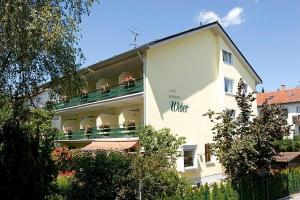 a white building with flowers on a balcony at Kurhotel Weber in Bad Wörishofen