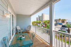 a balcony with a table and chairs and a view of a street at 2B Pavilion Watch in Folly Beach