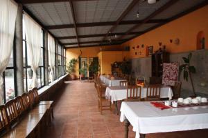 un restaurante con mesas y sillas blancas y ventanas en Villas Tonantzintla, en Cholula