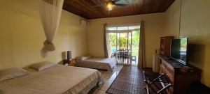 a bedroom with two beds and a flat screen tv at TEA TAHITI Holidays in Papeete
