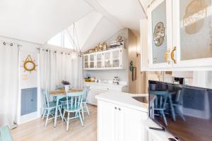 uma cozinha com armários brancos e uma mesa com cadeiras em Long Island Village Unit 659 Island Breeze em Port Isabel