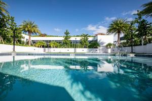 a swimming pool with palm trees and a building at Sonder 17WEST in Miami Beach