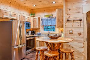a kitchen with a refrigerator and a table with stools at The Blue Spruce in Gatlinburg