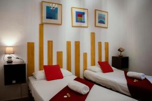 Habitación con 2 camas y almohadas rojas y blancas. en Casa Lemus, en Madrid 37 fotos más