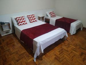 2 camas en una habitación con suelo de madera en Pax Hotel , próximo da 25 de Março, Brás, Bom Retiro e República, en São Paulo