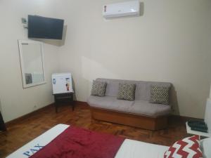 a living room with a couch and a flat screen tv at Pax Hotel , próximo da 25 de Março, Brás, Bom Retiro e República in São Paulo