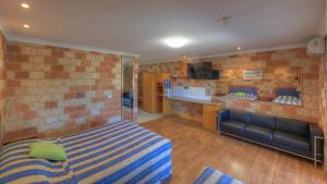 a bedroom with a bed and a couch in a room at Golfers Inn in Tenterfield