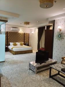a large hotel room with a bed and a tv at Al Hreer Hotel in Hafr Al Baten