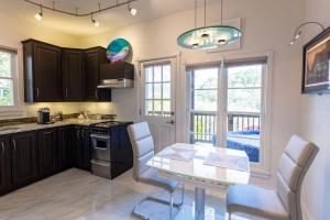 a kitchen with a table and chairs and some windows at Private Luxury Suite with Hot Tub Downtown Eureka Springs in Eureka Springs