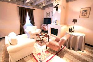 een woonkamer met witte meubels en een open haard bij Hotel Pago De Cirsus in Ablitas