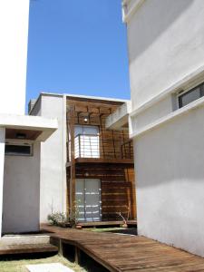 a building with a wooden deck next to a building at Los Duendes del Mar II in San Clemente del Tuyú