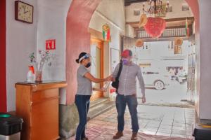 a man and a woman are standing in a room at Hotel Aurora in Oaxaca City
