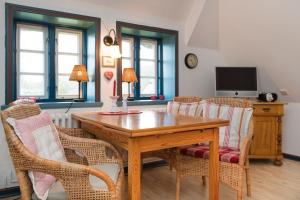 - une salle à manger avec une table et des chaises en bois dans l'établissement Hansen-Hof-Wohnung-2, à Tinnum
