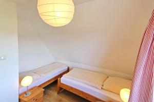 ヘルヌムにあるHildebrandのベッド2台とランプ付きの小さな部屋です。