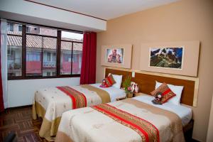 um quarto de hotel com duas camas e uma janela em Euler House`s em Cusco
