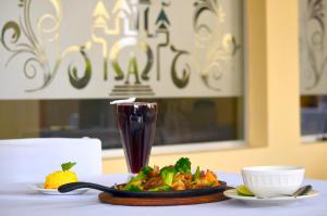 a plate of food on a table with a drink at Hotel y Restaurante Castillo de los Altos in Quetzaltenango
