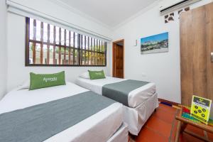 two beds in a room with a window at Hotel Ayenda Casa Cano 1805 in Cartagena de Indias