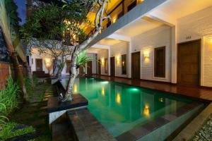 an infinity pool in a villa at night at Echoland Boutique Bed And Breakfast in Canggu