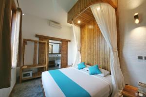 a bedroom with a large bed with blue pillows at Echoland Boutique Bed And Breakfast in Canggu +23 photos