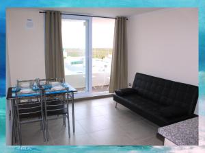 salon z czarną kanapą i stołem w obiekcie Nuevo y Exclusivo Condominio - Acceso Directo a la Playa w mieście La Serena