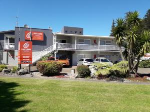 a building with cars parked in a parking lot at Lake Lodge Motel Rotorua in Rotorua