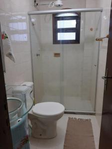 a bathroom with a toilet and a shower with a window at Vista Panorâmica em São Pedro da Aldeia in Rio de Janeiro